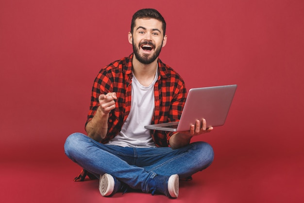 Портрет счастливого молодого человека с помощью ноутбука