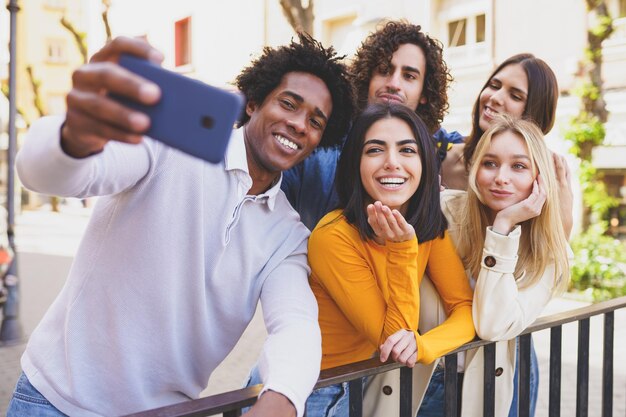 Photo portrait of happy young man using smart phone