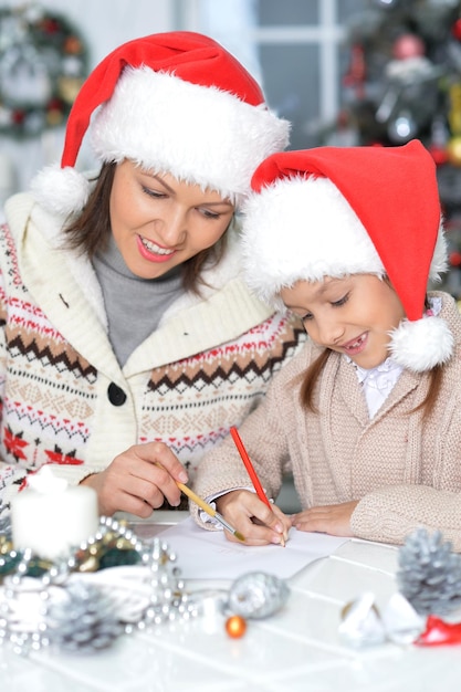 Portrait of happy young mother and daughter preparing for Christmas