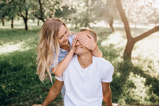 Portrait happy young smiling couple in love over flowering spring garden