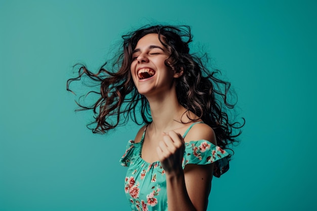 Portrait of a happy young woman laughing on a turquoise background stock photo