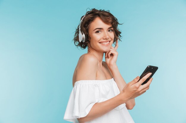 Portrait of a happy young woman listening to music