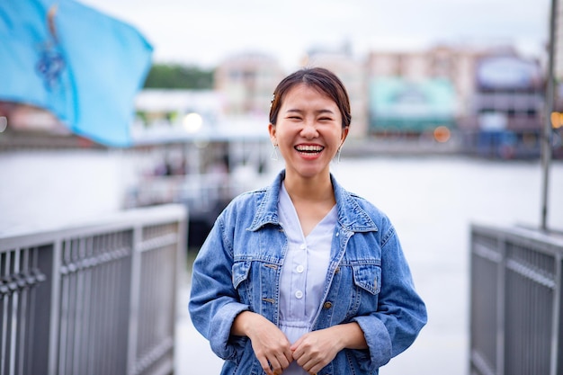 Photo portrait of happy young woman standing against river