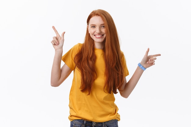 Portrait of happy young woman standing isolated over white wall