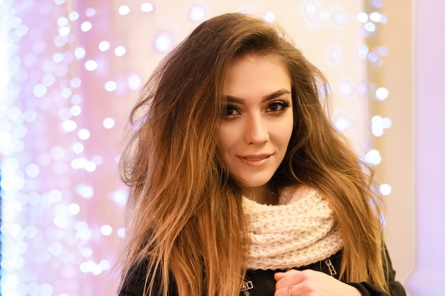 Photo portrait of a happy young woman on the street with a garland