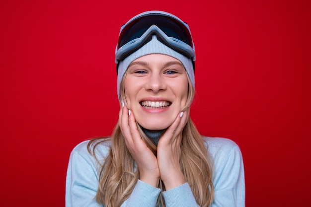 Portrait of a happy young woman in a sweater and ski goggles