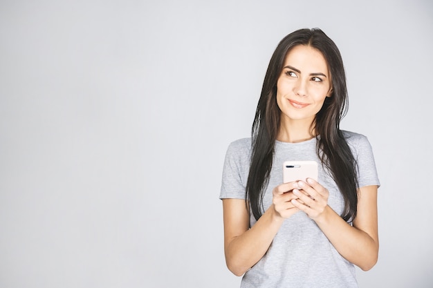 Портрет счастливой молодой женщины с помощью мобильного телефона