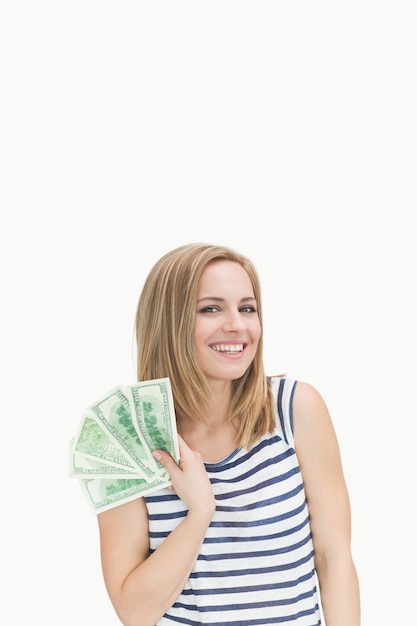 Portrait of happy young woman with fanned dollars