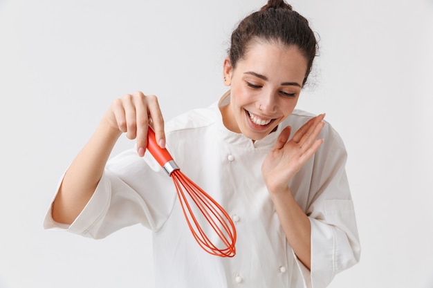 Portrait of a happy young woman with kitchen utensils