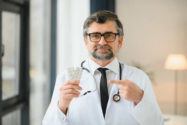 Portrait of healthcare worker Image of senior male doctor wearing lab coat and standing at private clinic