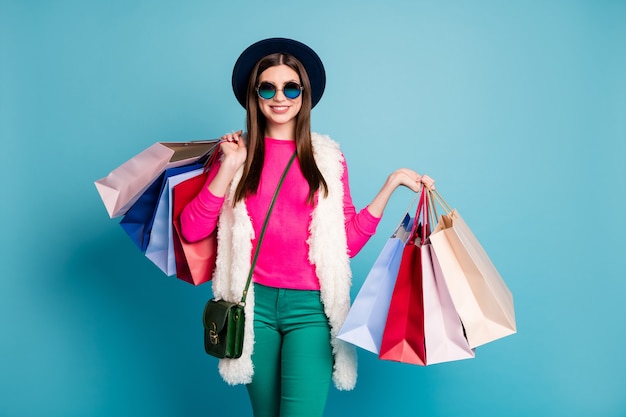 Portrait of her she nice attractive cheerful cheery girl carrying new clothing things spending holiday isolated on bright vivid shine vibrant green blue turquoise color wall