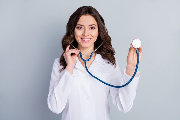 Portrait of her she nice attractive lovely cheerful cheery wavyhaired girl doc listening breath medical insurance assistance infection isolated over grey pastel color background