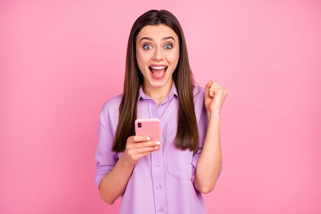 Portrait of her she nice attractive lovely pretty charming amazed cheerful cheery long-haired girl using cell fast speed internet online connection isolated over pink pastel color background