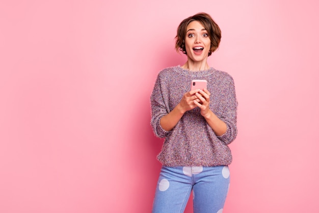 Portrait of her she nice attractive lovely pretty charming cheerful cheery glad excited brown-haired girl using cell great news 5g isolated over pink pastel color wall