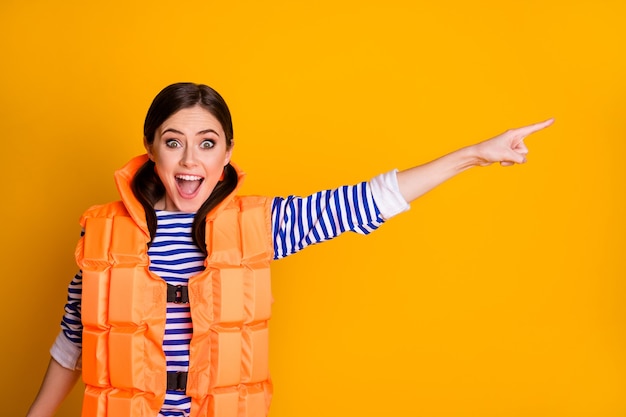 Portrait of her she nice attractive pretty lovely charming glad cheerful girl wearing lifesaver showing copy space solution advice isolated over bright vivid shine vibrant yellow color background