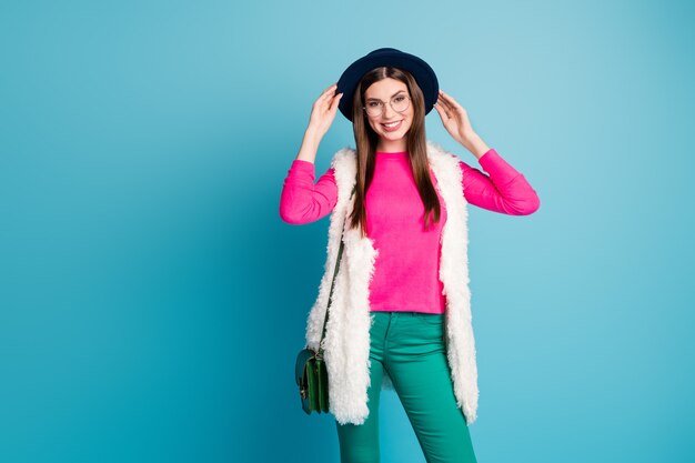 Portrait of her she nice-looking attractive pretty fashionable cheerful cheery girl posing touching hat isolated on bright vivid shine vibrant green blue turquoise color wall