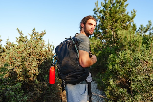 Portrait of hiker man with backpack trekking in the mountains