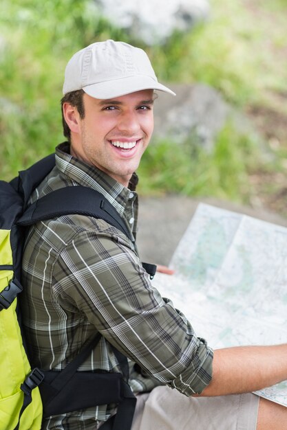 Portrait of hiker with map on rock