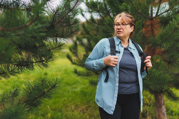 Portrait of a hiker woman lost in forest She using mobile GPS map Woman experiencing fear and confusion