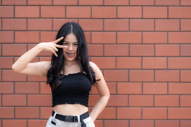 Portrait of hipster girl on brick wall backgroundBeautiful asian woman pose for take a photoKawaii style