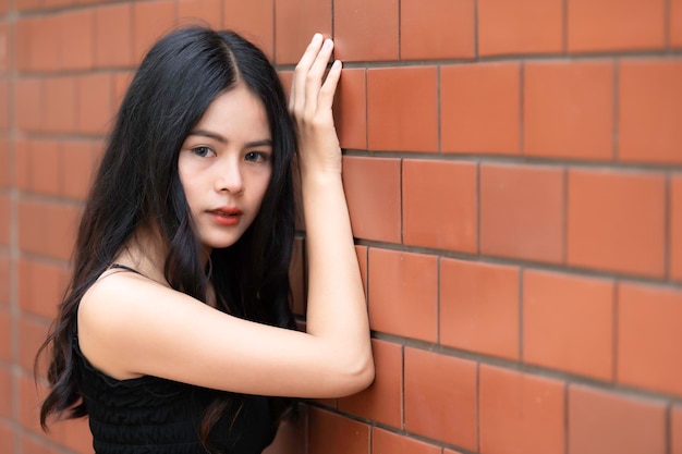 Portrait of hipster girl on brick wall backgroundBeautiful asian woman pose for take a photoKawaii style