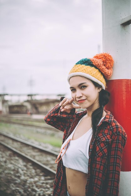 流行に敏感な女の子の肖像画は、写真を撮るためにポーズをとって鉄道ヴィンテージスタイルタイの女性に座っています