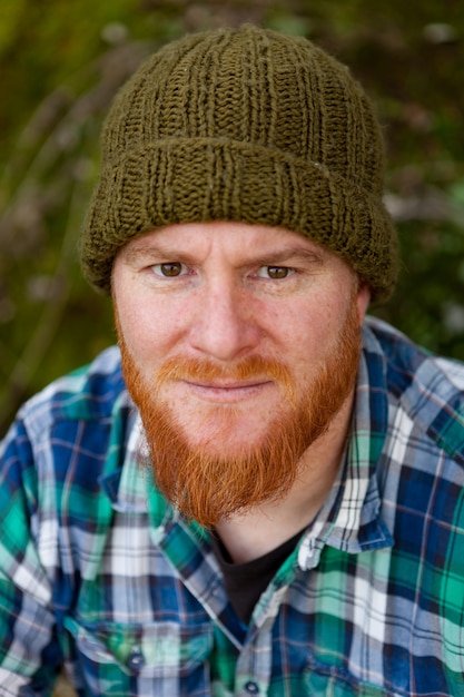 Portrait of a hipster guy thinking in the forest