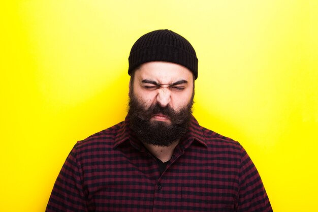 Portrait of hipster man with a long beard on a yellow background