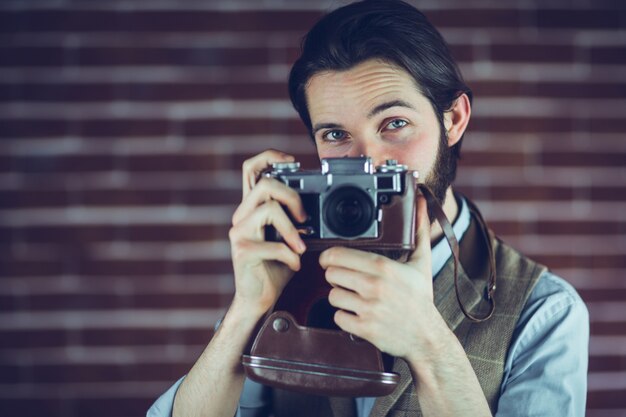 Portrait of hipster taking picture through camera