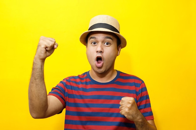 Portrait of Hipster young man young happy man casual dress red striped tshirt and wear a hats Gesture emotion extend the arms shy modest on studio portraits set color yellow background