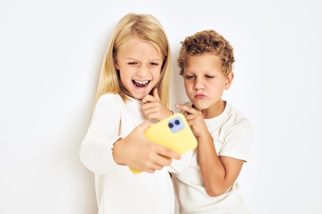 Portrait of his he her with yellow phone entertainment\
lifestyle childhood. high quality photo