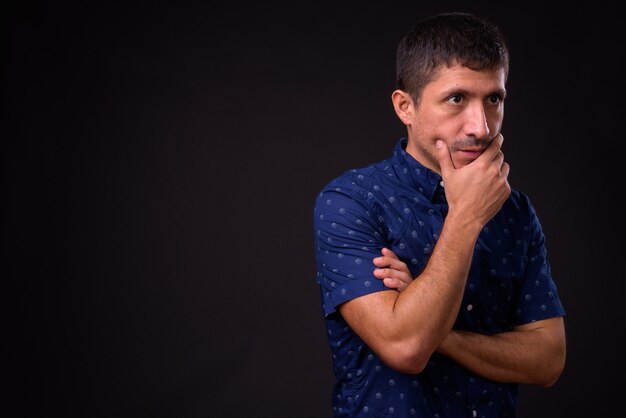 Portrait of Hispanic businessman against black background