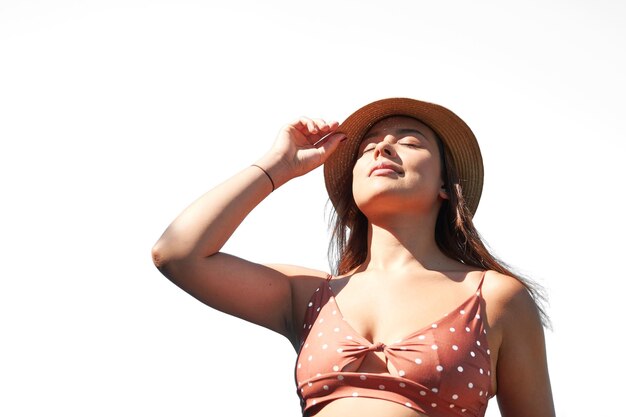 Portrait of a Hispanic young woman wearing a hat on a white background