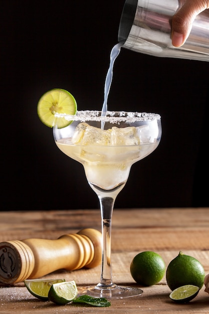 Photo portrait of homemade classic margarita poured into a glass with lime and salt