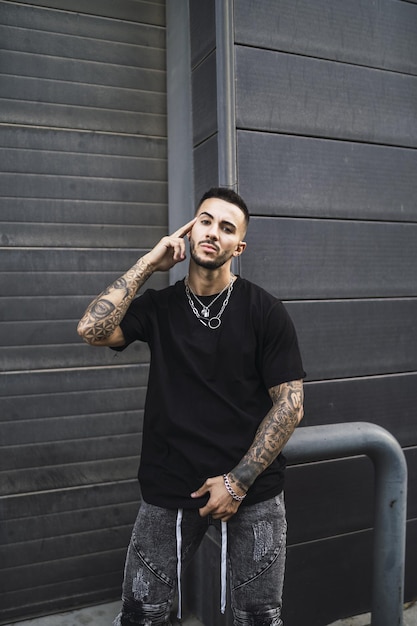 Portrait of a hot young stylish man wearing a black T-shirt and gray jeans