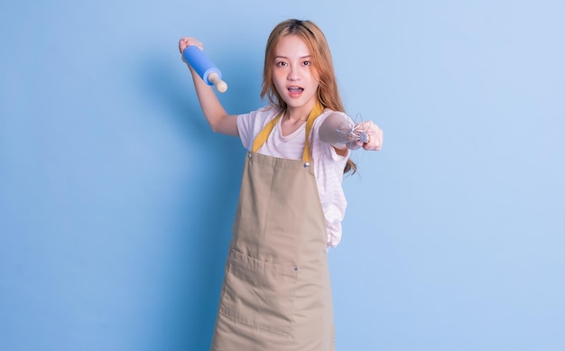 Portrait of housewife posing on blue background