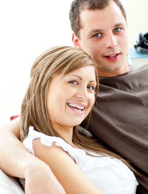 Portrait of a hugging couple sitting on a sofa 