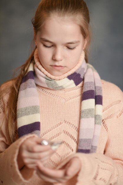 Portrait of ill girl holding pills in hand