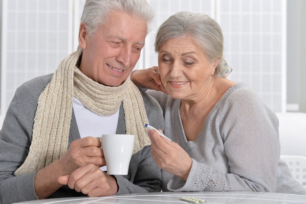 Ritratto di una coppia anziana malata con termometro