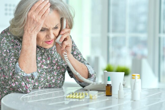 Photo portrait of ill senior woman calling doctor