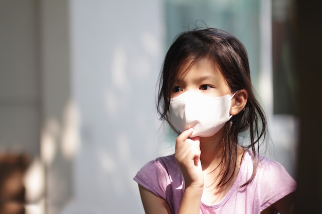 portrait image of Asian primary school little girl wearing mask for coronavirus prevention