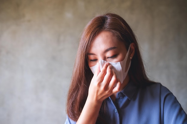 Portrait image of an asian woman putting on protective face mask for Healthcare and Covid19 concept