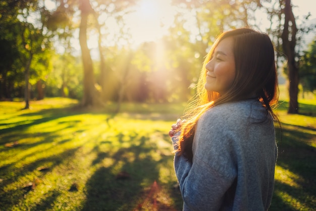 Portrait image of a beautiful asian woman standing among nature in the park before sunset