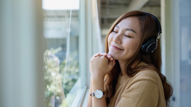 Portrait image of a beautiful young asian woman enjoy listening to music with headphone