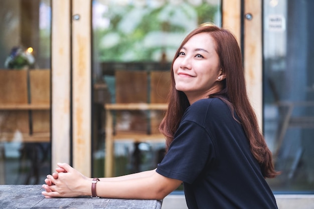 Portrait image of a beautiful young asian woman sitting in the outdoors