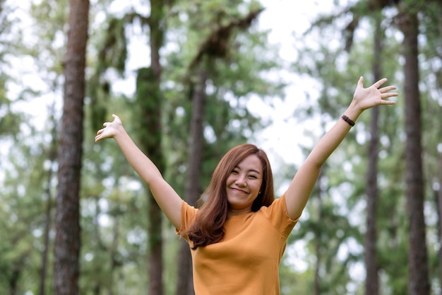 Immagine ritratto di una donna felice con le braccia in aumento nel parco