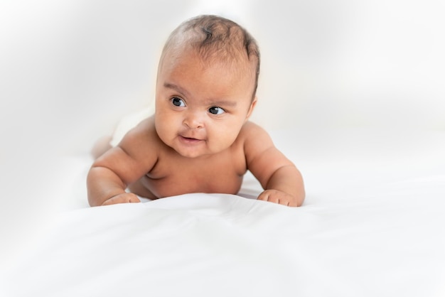 Portrait images of African baby newborn girl is 3 month year old Lying on white bed in bedroom