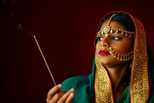 Portrait indian beautiful female in golden rich jewelery and tradition saree face closeup professional makeup wearing bindi on head Muslim Woman face portrait with bindis maang tikka nathnose Pin