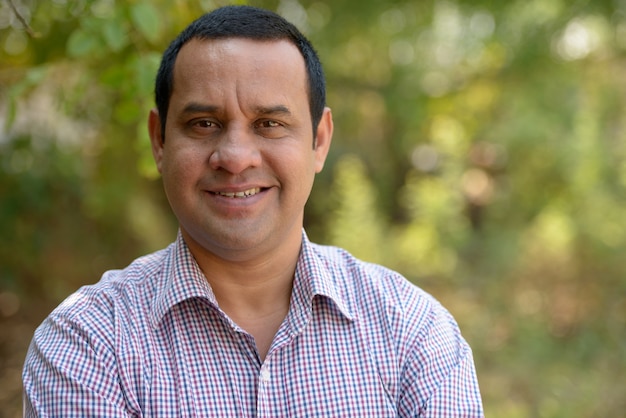 Portrait of Indian businessman with short hair relaxing at the park outdoors