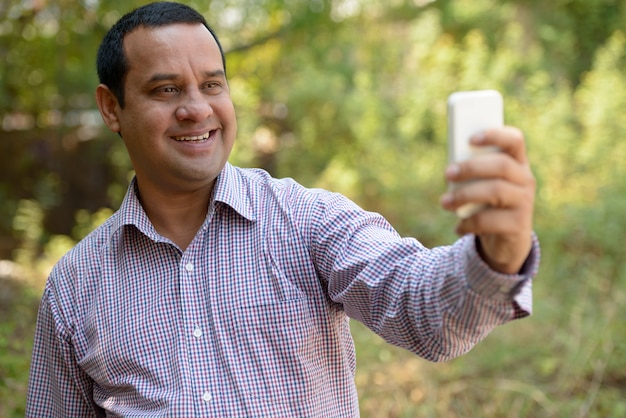 Portrait of Indian businessman with short hair relaxing at the park outdoors